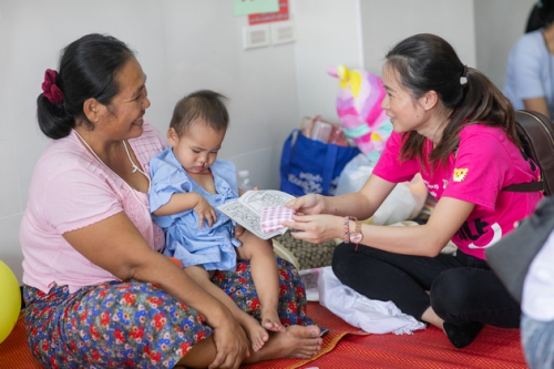 Christie Yeung (right) reaches out to the cleft children and their parents, bringing them colouring books and warm blessing